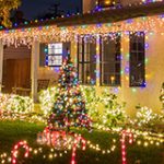 Exterior of a house and a holiday tree covered with lights.