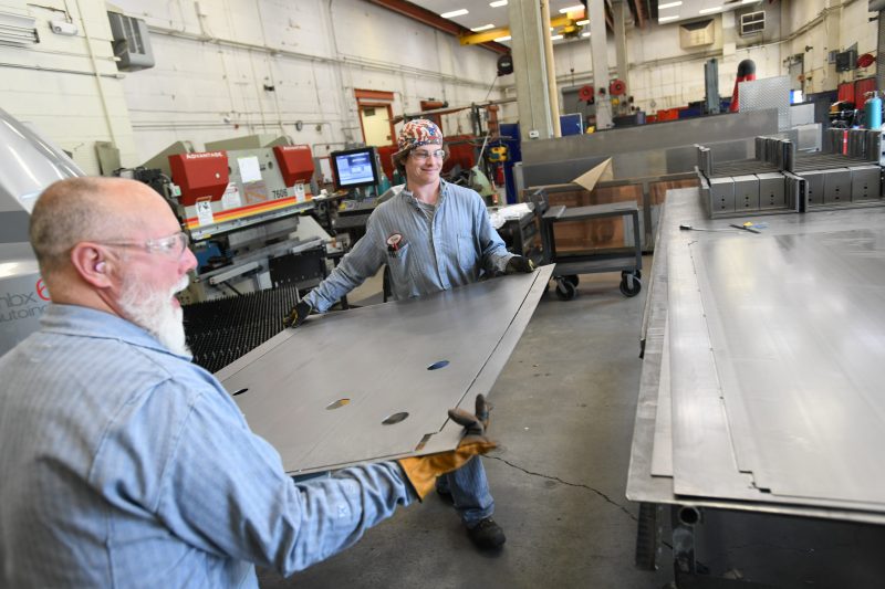 Image of two mechanics working in a fabrication shop.