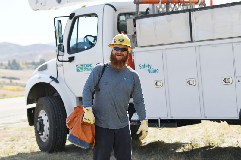 Image of a line crew worker in front of an Idaho Power bucket truck.