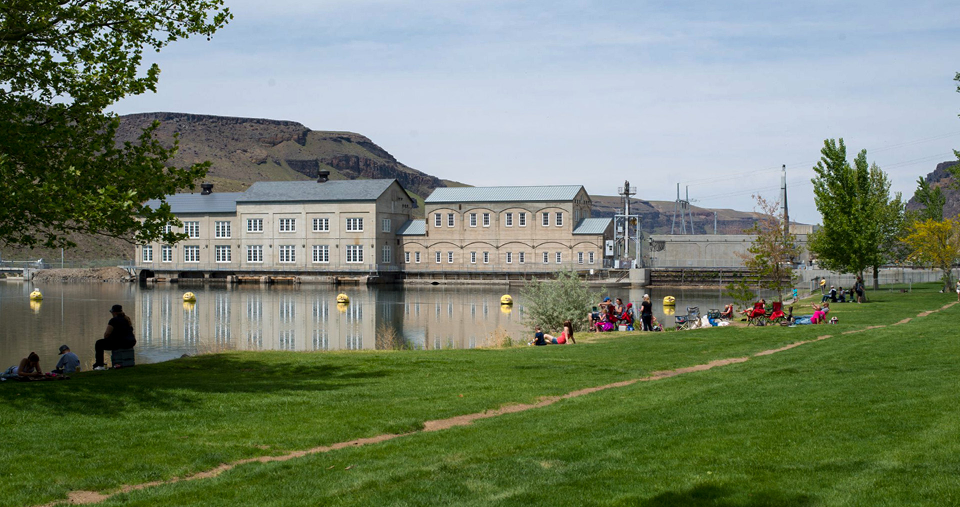 people relaxing at swan falls park. the power station is in the background.