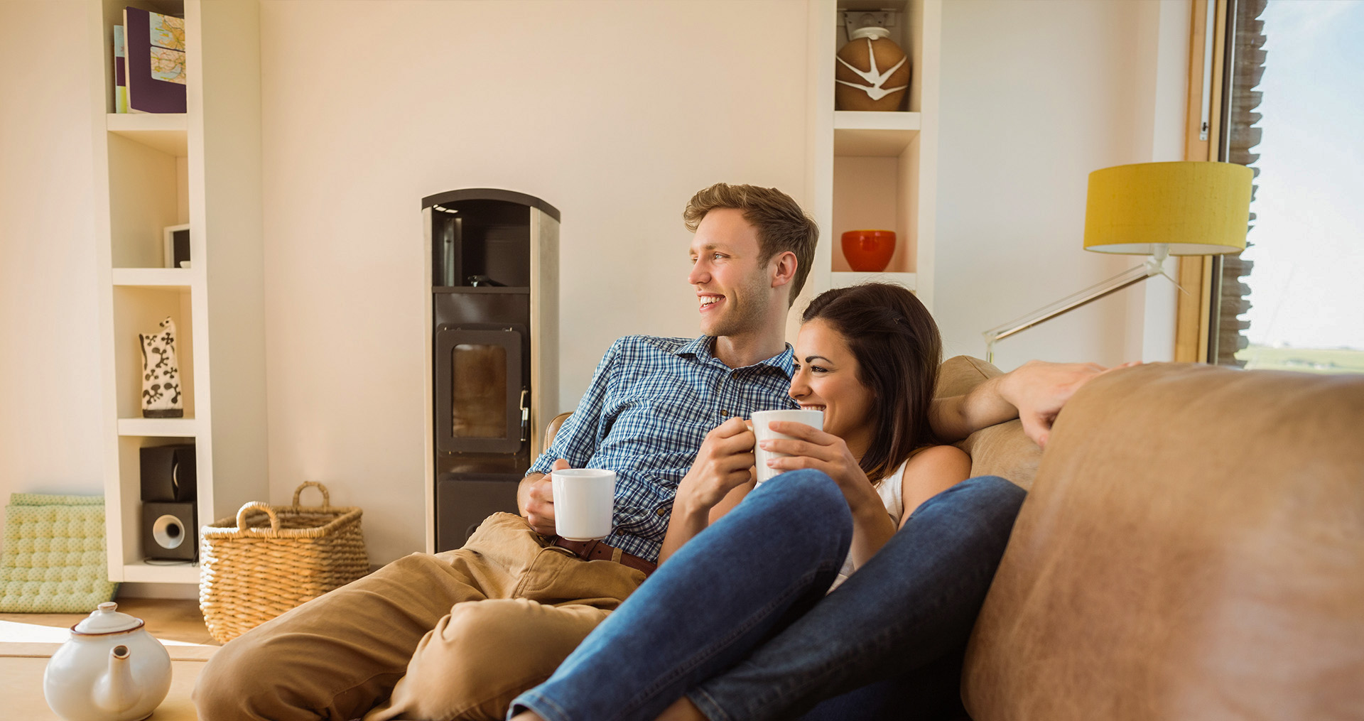 a man and woman sitting on a couch in their living room